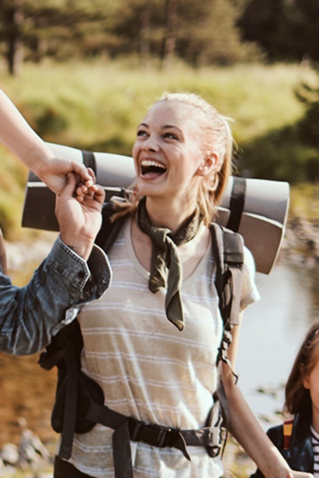 Eine Familie wandert auf einem Pfad durch den Wald.
