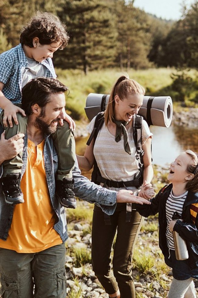Eine Familie wandert auf einem Pfad durch den Wald.