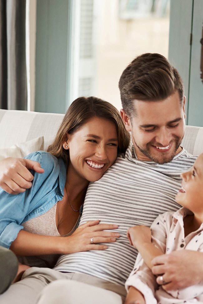Glückliche Familie, die auf einer Couch sitzt