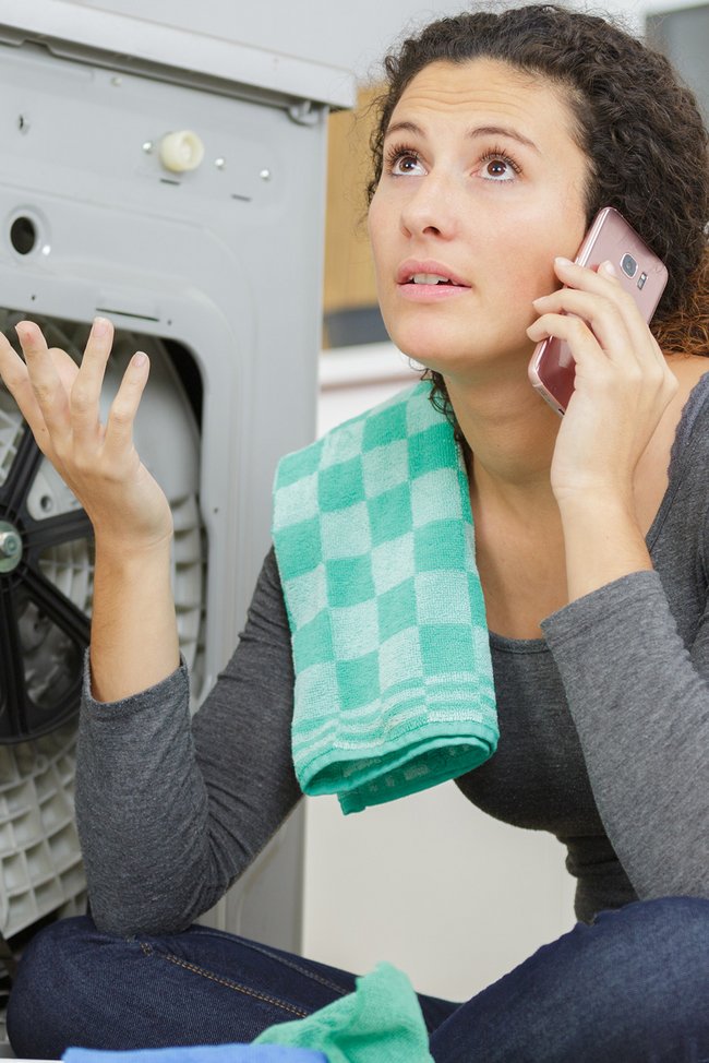 Frau ruft den Techniker wegen einer defekten Waschmaschine an.